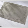A rectangular linen placemat in a light gray color with decorative stitching is displayed on a white surface.