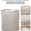 A striped cotton and linen laundry basket used for dirty clothes storage.