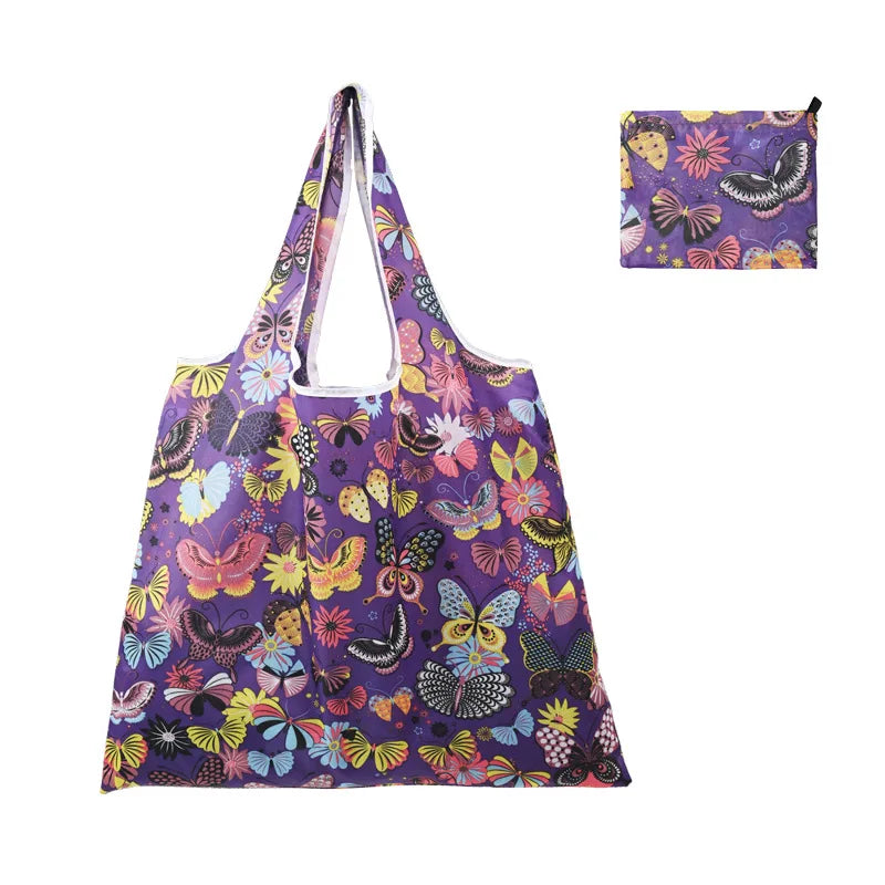 A purple fabric reusable shopping tote bag featuring a vibrant pattern of colorful butterflies and floral designs.
