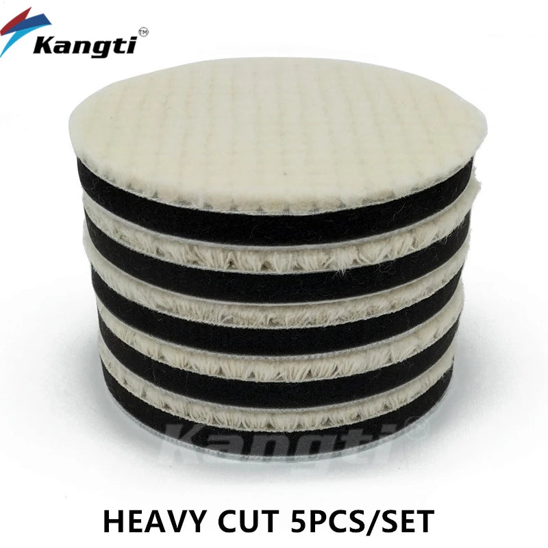 A set of five heavy cut black and white polishing wool pads with foam backing for scratch removal