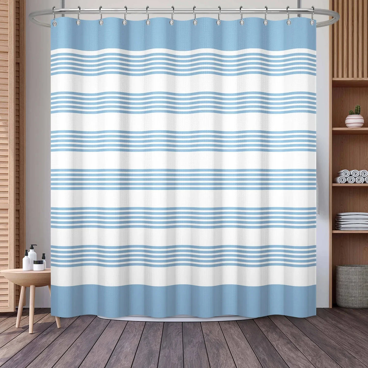 A light blue and white striped waffle weave shower curtain hanging on a rod.