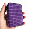 Purple plaid compact EDC utility pouch with black lining and zipper on a hand