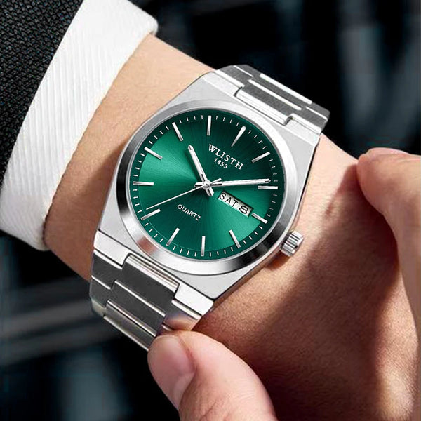 A silver-toned men's quartz watch with a green dial and stainless steel band worn on a wrist.