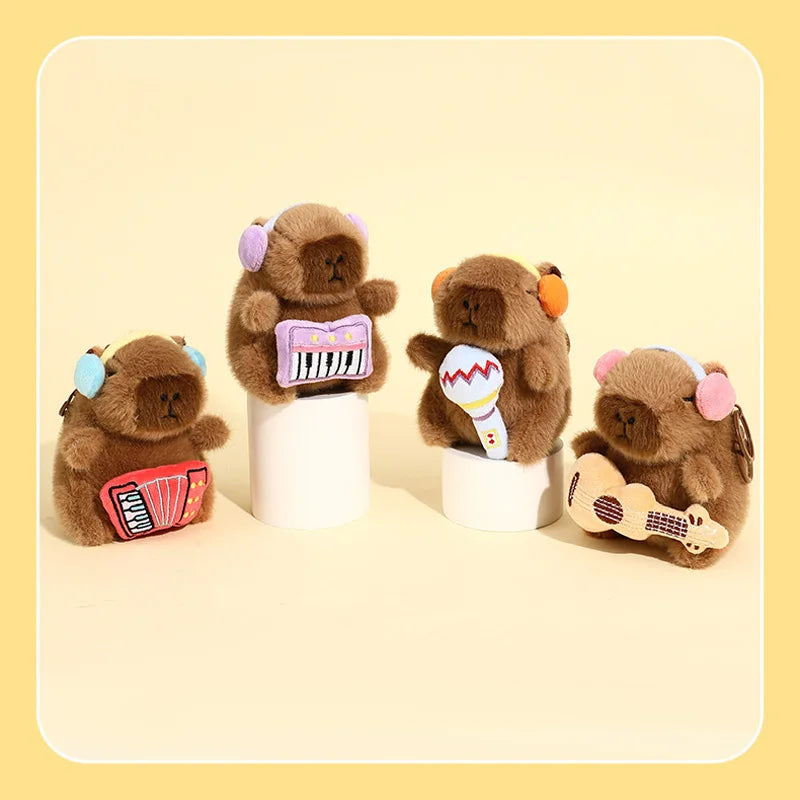 Three brown capybara plush toys with musical instruments are displayed on a light background.