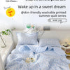 A light blue floral quilted summer quilt is displayed on a bed, emphasizing its soft and gentle care.