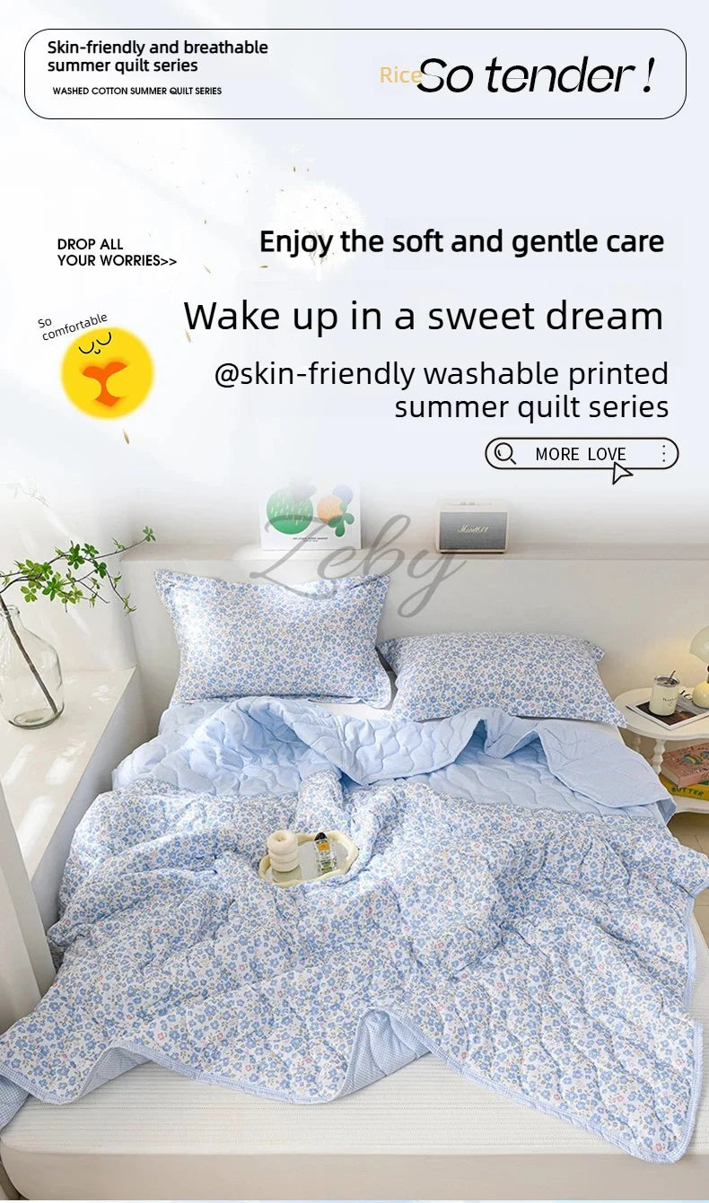 A light blue floral quilted summer quilt is displayed on a bed, emphasizing its soft and gentle care.