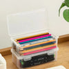 Clear plastic storage box with a lid filled with colored pencils and other art supplies