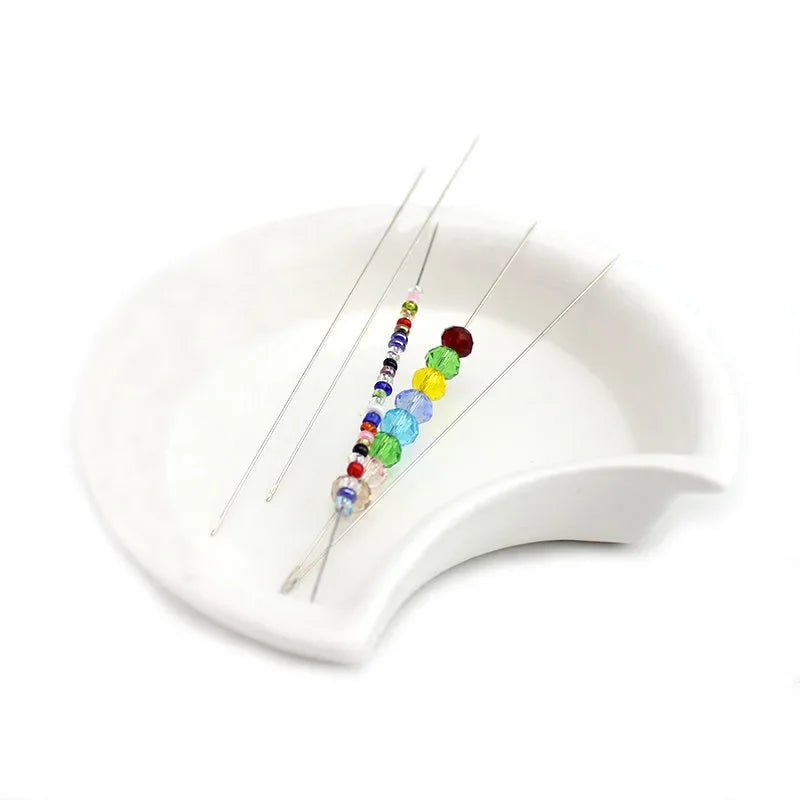 A set of stainless steel beading needles with colorful beads for jewelry making