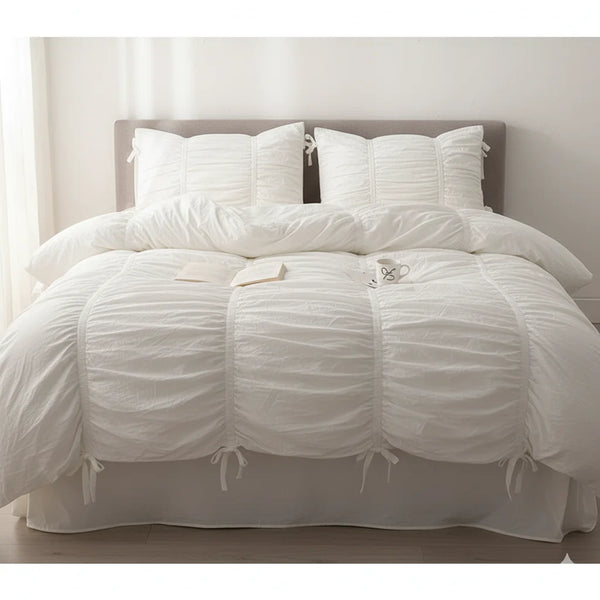 Pure white washed cotton ruffle bedding set with bow ties on a bed