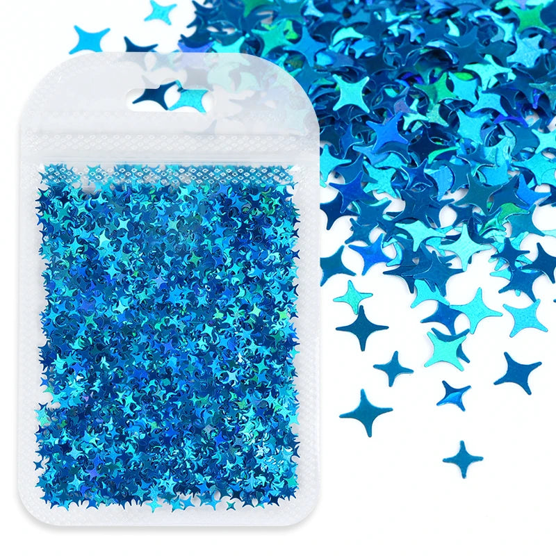 A white adhesive backing sheet filled with blue and teal holographic star sequins for resin crafts.