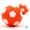 Two bright orange and white foosball balls are shown on a white surface.