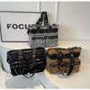 A display of black and white nylon shoulder bags with chain accents, featuring striped and solid fabric designs.