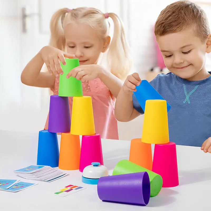 Two children are stacking colorful plastic cups and matching cards for a game.