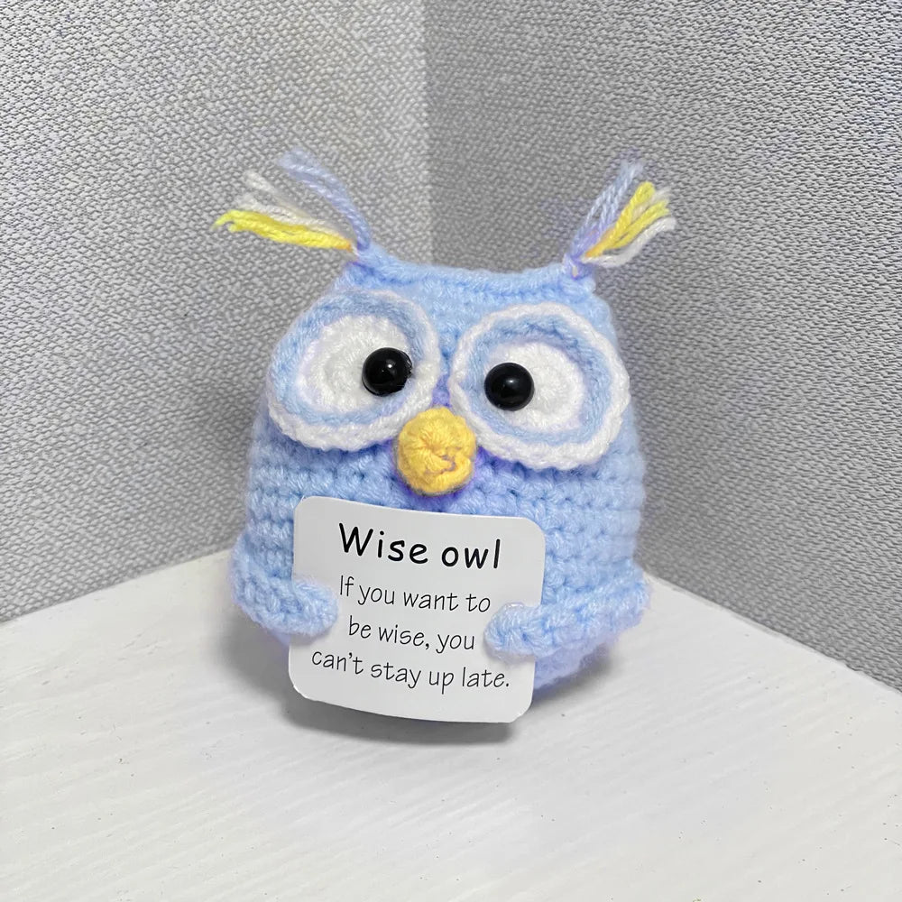 Handmade crochet owl doll with blue body and yellow accents, featuring a humorous quote about wisdom.