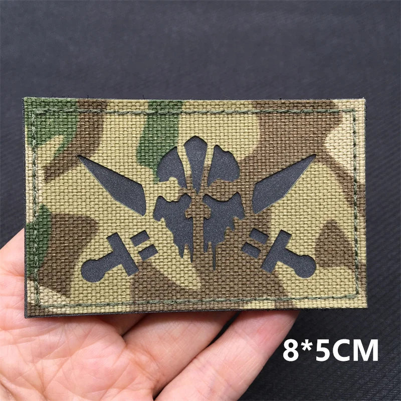 A close-up of a camouflage tactical patch featuring a national flag design on a fabric background.