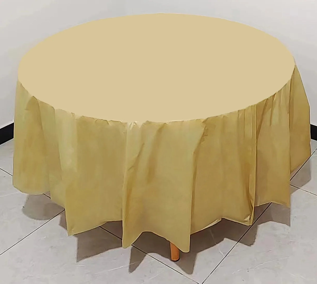 A round table covered with a light yellow or beige disposable tablecloth.