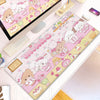 A pink and white kawaii cartoon gaming desk mat featuring cute characters and food items with a non-slip rubber base.