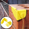 Yellow masonry line corner clips with anti-slip locks being used to secure a line on a brick wall.