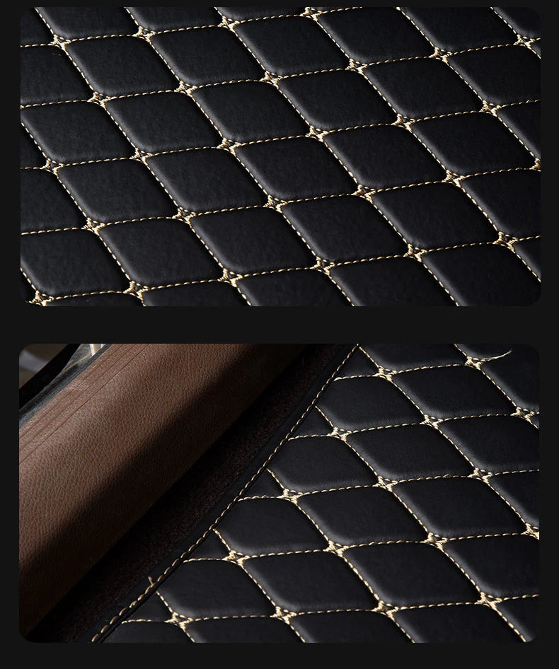 Close-up view of black quilted leather car floor mats with gold stitching.