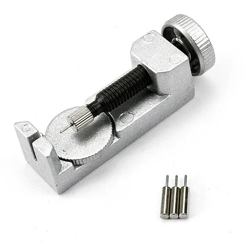 A silver watch band link remover and pin extractor kit with a threaded tool and several pins.