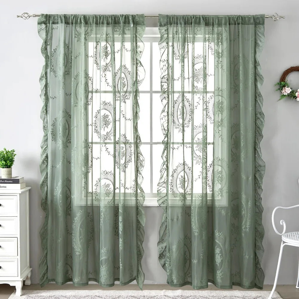 Sheer sage green floral embroidered curtains with ruffled French lace detailing hanging in a window.