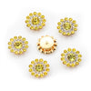 A collection of yellow and clear flower-shaped rhinestones arranged on a white background.