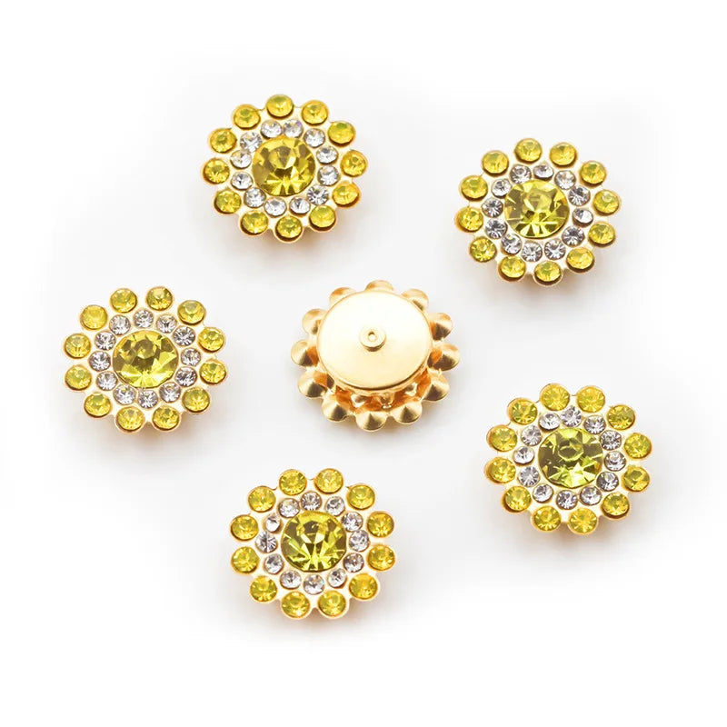 A collection of yellow and clear flower-shaped rhinestones arranged on a white background.