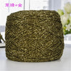 A ball of metallic gold or silver shimmering silk crochet yarn used for knitting and macrame.