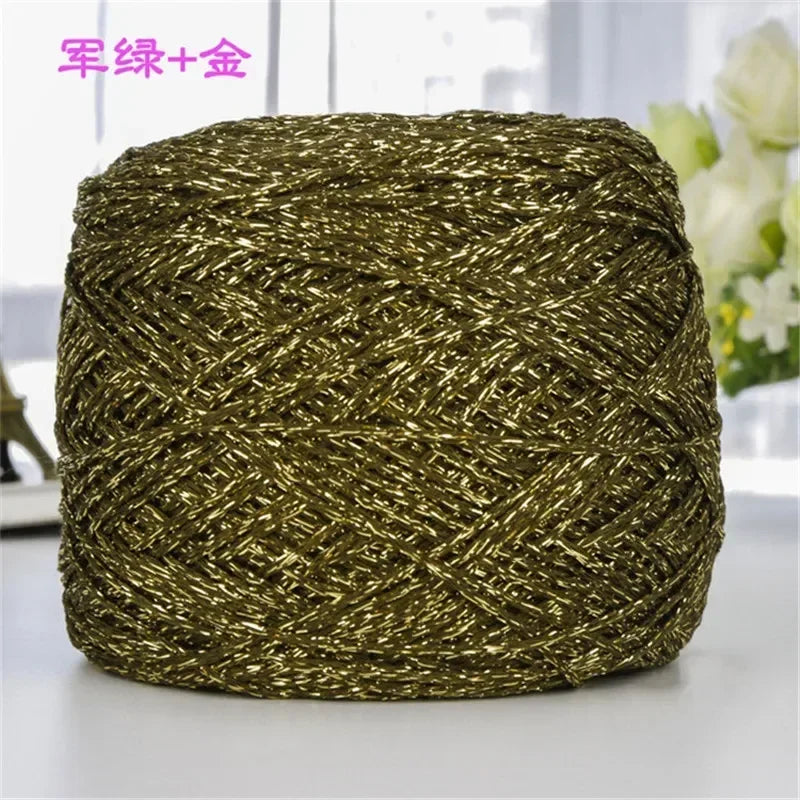 A ball of metallic gold or silver shimmering silk crochet yarn used for knitting and macrame.