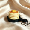 A stack of round, layered silicone or plastic discs in yellow and orange rests on a black keychain.