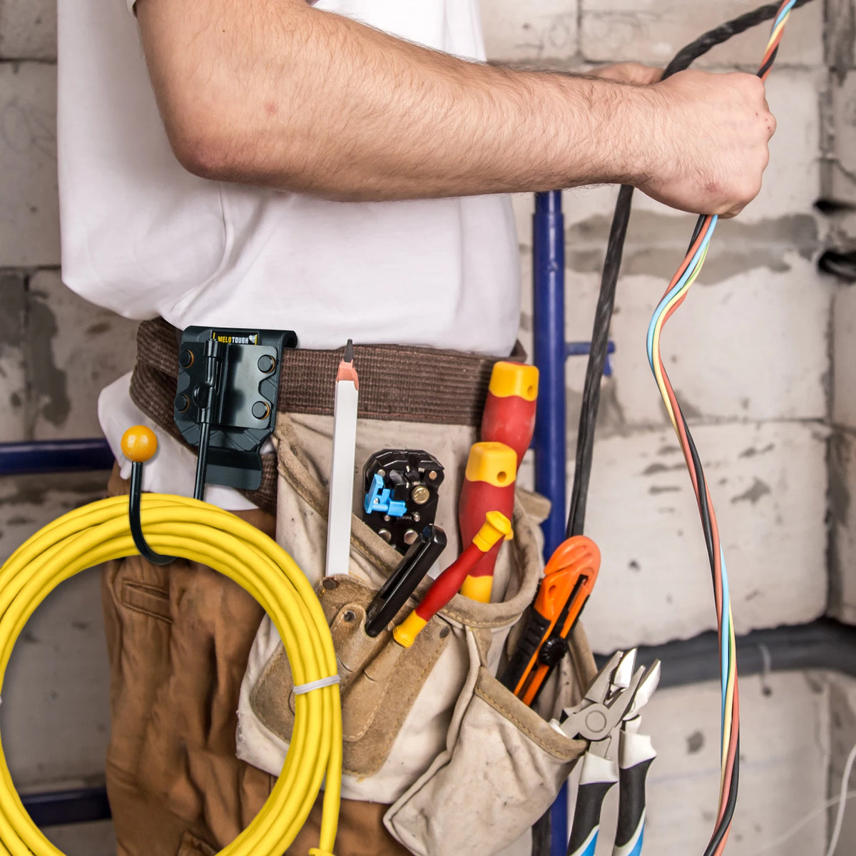 A person is holding a rotating tool belt hook for drills and work gear, showing various tools and accessories.