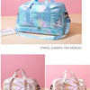 A light blue iridescent travel duffel bag with pink accents shown against a pink background.