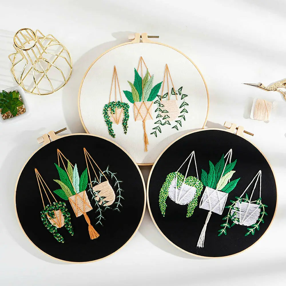 A set of floral cross stitch embroidery kits featuring green leaves and vines on white and black fabric.