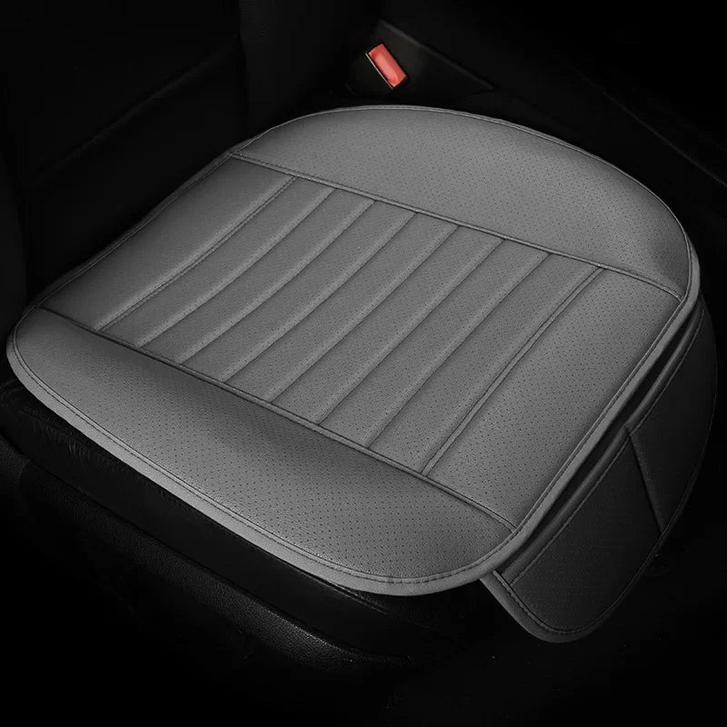 A gray breathable PU leather car seat cover with vertical stitching is shown in a dark vehicle interior.