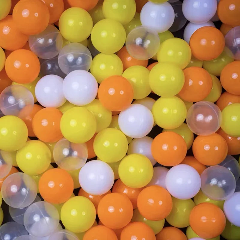 A close-up view of a large pack of colorful plastic ball pit balls in shades of orange, yellow, and white.