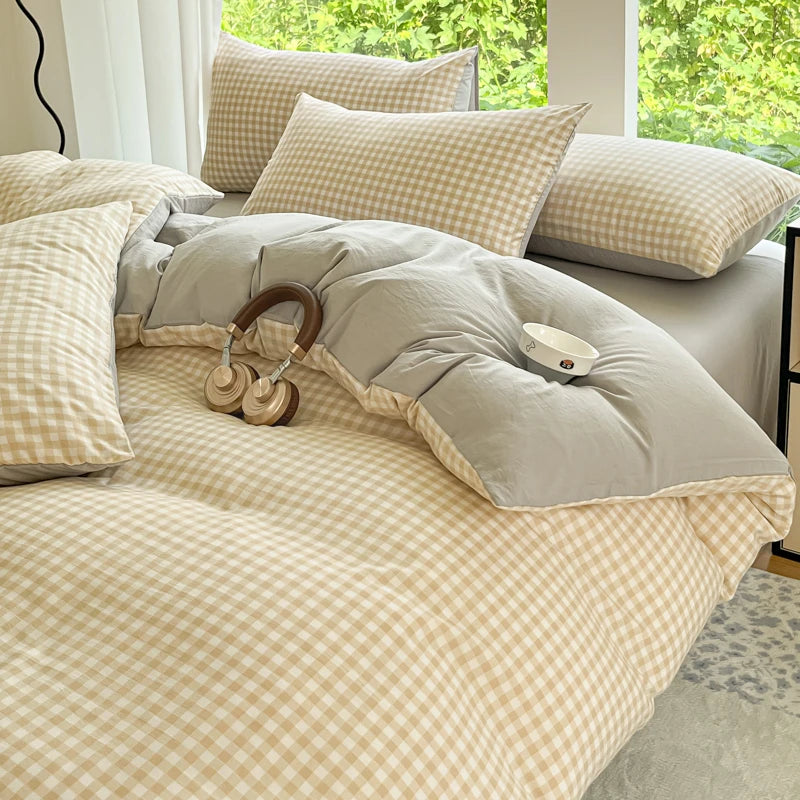 A beige and cream gingham duvet cover set with two pillows on a bed near a window.