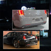 Close-up view of a silver Chrysler 300 rear bumper with aftermarket red reflector light covers.