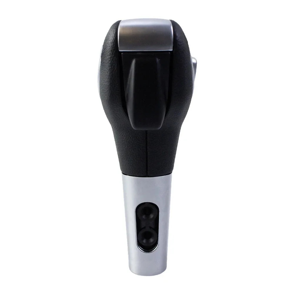 A close-up view of a leather-wrapped gear shift knob with a silver base and black top.