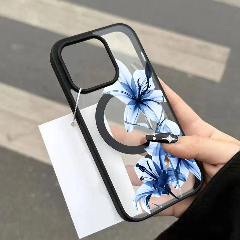 A hand holds a clear phone case featuring a blue lily design with a magnetic closure.