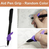 A hand holds a black pen with a purple grip writing on a lined paper, demonstrating the aid pen grip.