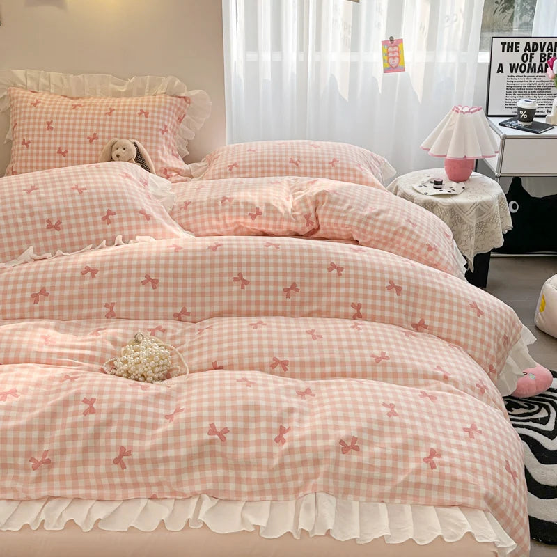 A set of three pink and white patterned ruffled duvet covers displayed on a bed.