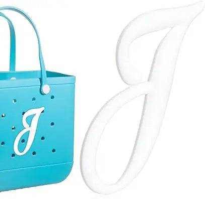 A light blue bag charm shaped like the letter B and a white loop charm.