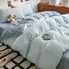 A light blue ultra-soft washed cotton duvet cover set with a matching duvet and pillows on a bed.