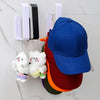 A blue baseball cap and a pair of white plush toys are displayed on a white marble surface with wall mounts.