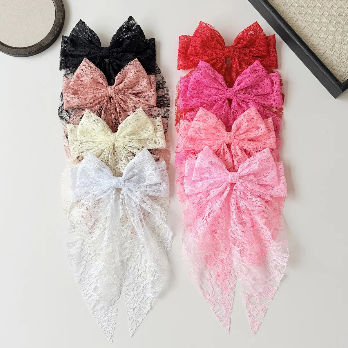 A collection of pink, red, and beige lace bow hair clips for women in various shades