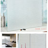 Close-up of a silver striped privacy window film installed on a window, demonstrating its texture and application.