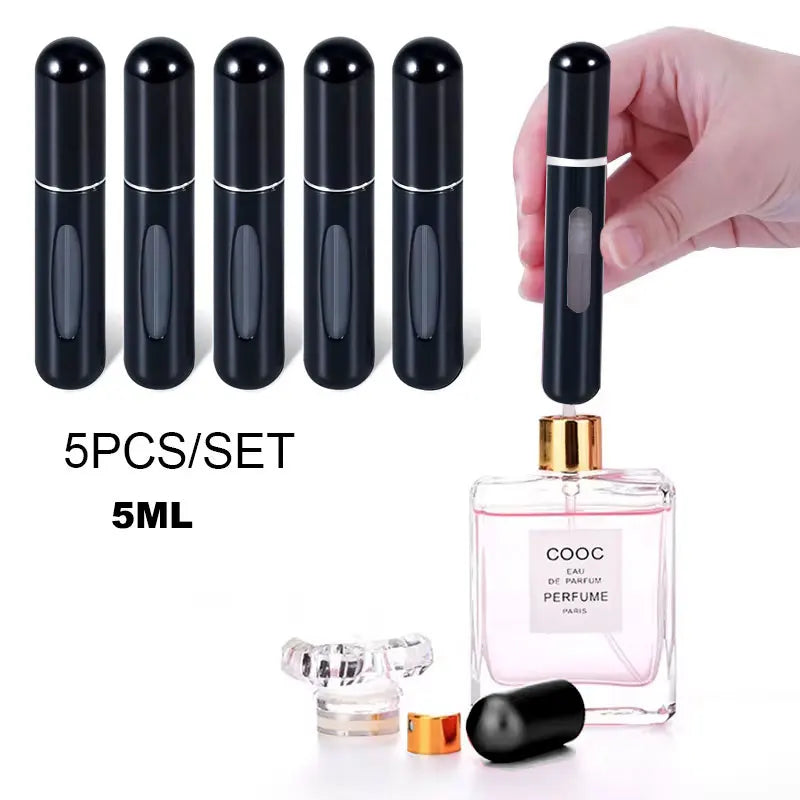 A set of five black glass perfume spray bottles with gold accents and a hand holding one bottle over a pink glass perfume bot