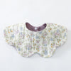 A light-colored cotton baby feeding bib with a floral pattern and a brown underside.