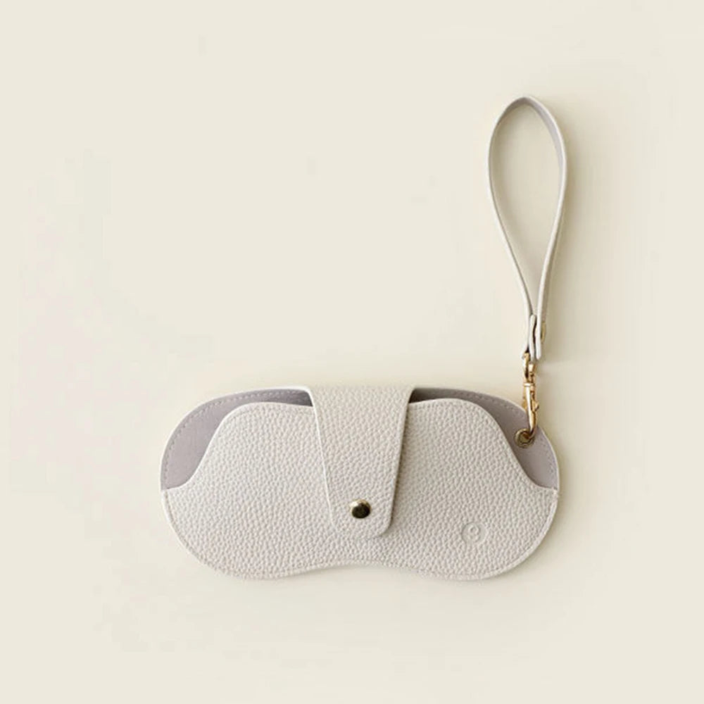 A light beige retro lychee pattern PU leather glasses case with a gold-tone strap.