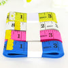 A colorful flexible soft tape measure with dual-sided markings in yellow, pink, and blue.